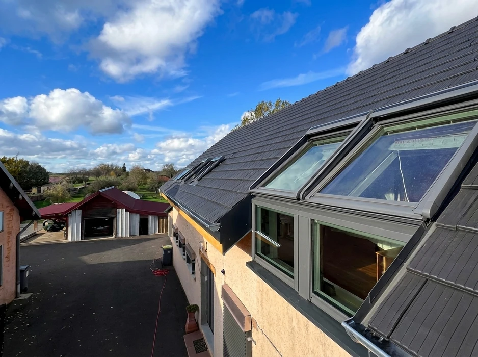 Toiture en tuiles ardoisées avec fenêtres de toit VELUX en saillie, vue extérieure en plongée