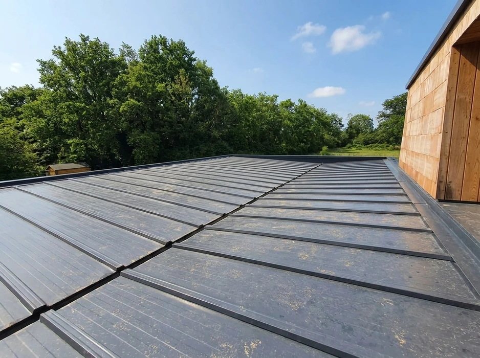Toiture en zinc à joint debout vue de dessus, avec des bandes de zinc anthracite assemblées par agrafage