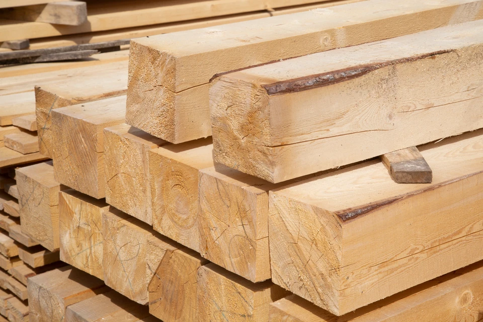Extérieur d'un chantier ou dépôt de matériaux de construction avec empilage de poutres en bois massif