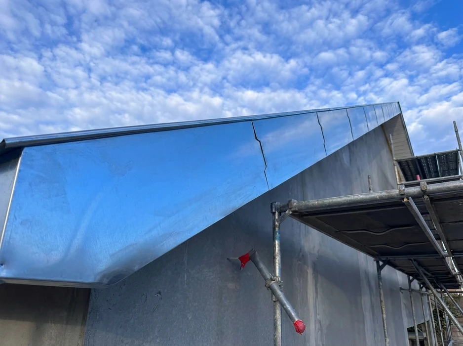 Chantier de réfection de toiture en extérieur, vue en plongée depuis un échafaudage métallique tubulaire